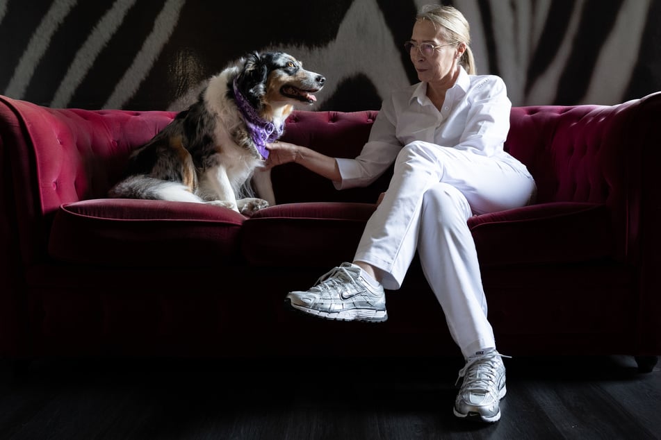 Zahnärztin Ina Zöller sitzt mit Hündin "Anouk" auf einem Sofa im Wartezimmer ihrer Praxis. Die Hündin soll auf ängstliche Patienten beruhigend wirken.