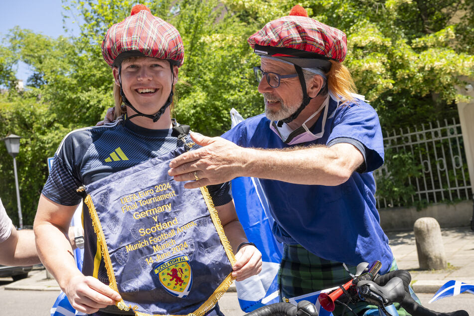 Ethan Walker (19, l.) aus Huntly (Schottland) und sein Arzt Gordon Mackay stehen nach der Fahrt mit dem Fahrrad von Glasgow nach München vor dem britischen Konsulat.