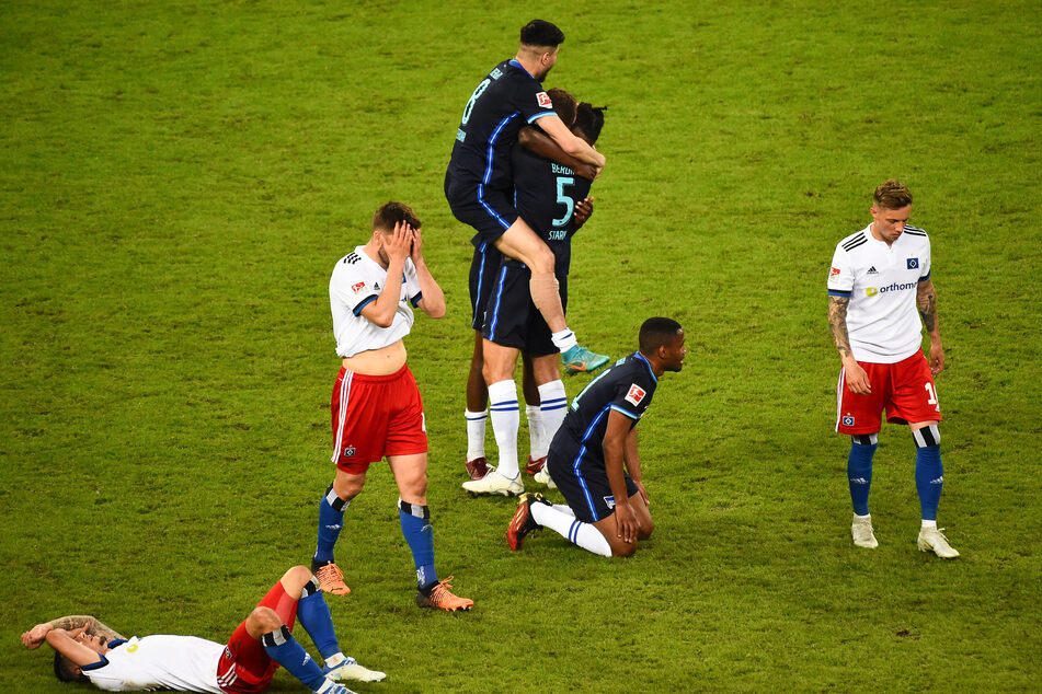 Nach der Partie: Spieler von Hertha jubeln während die HSV-Profis am Boden zerstört sind.