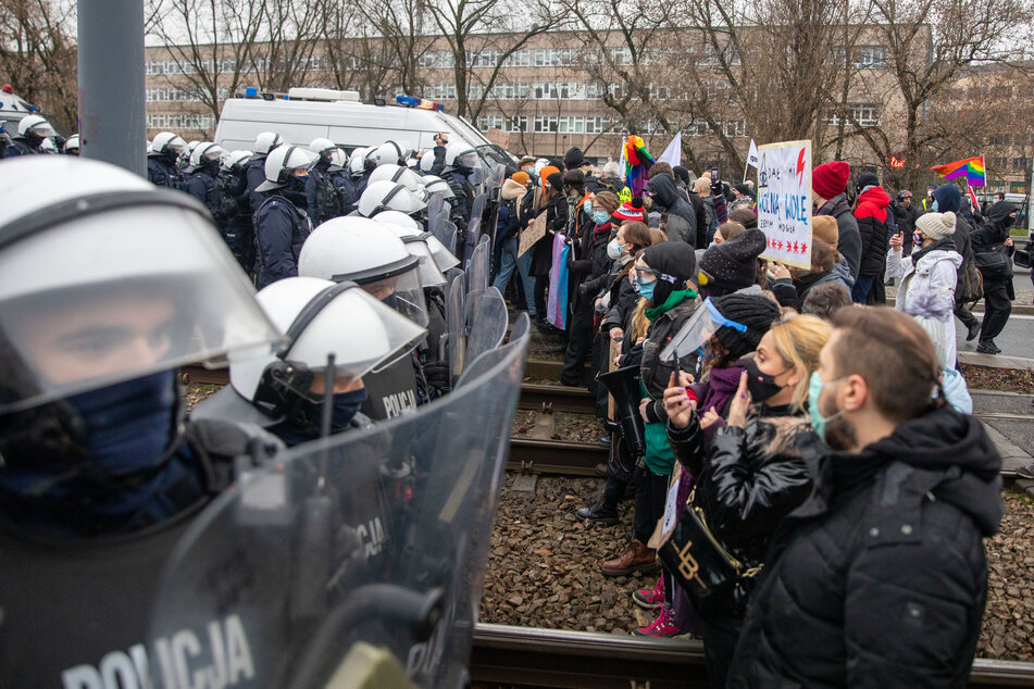 Polnische Demonstranten stehen während einer Protestkundgebung im Dezember 2020 vor einer Reihe von Bereitschaftspolizisten.