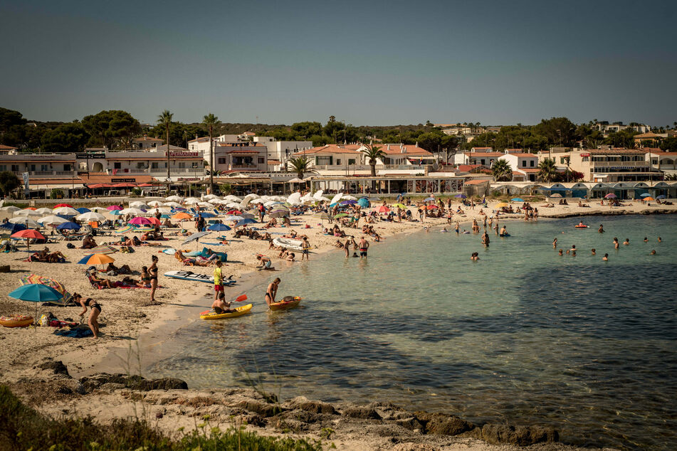 Urlauber kühlen sich am Strand Punta Prima in Sant Lluis, im Süden von Menorca, ab. Seit Ende Juni sind die Corona-Zahlen praktisch überall in Spanien rapide in die Höhe geschossen.