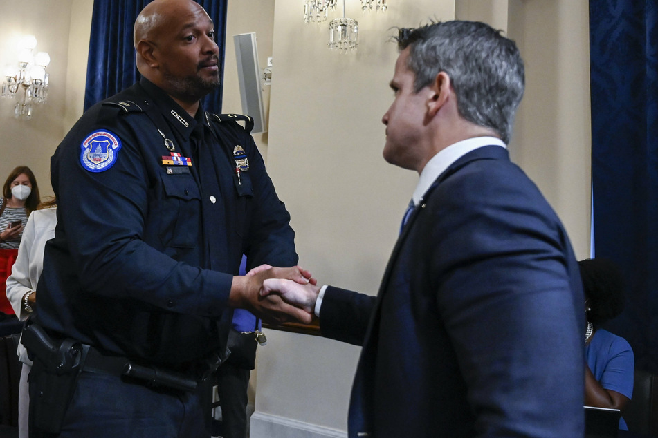 Kinzinger (r.) shakes hands with Capitol Police Officer Harry Dunn after the opening hearing of the January 6 probe.
