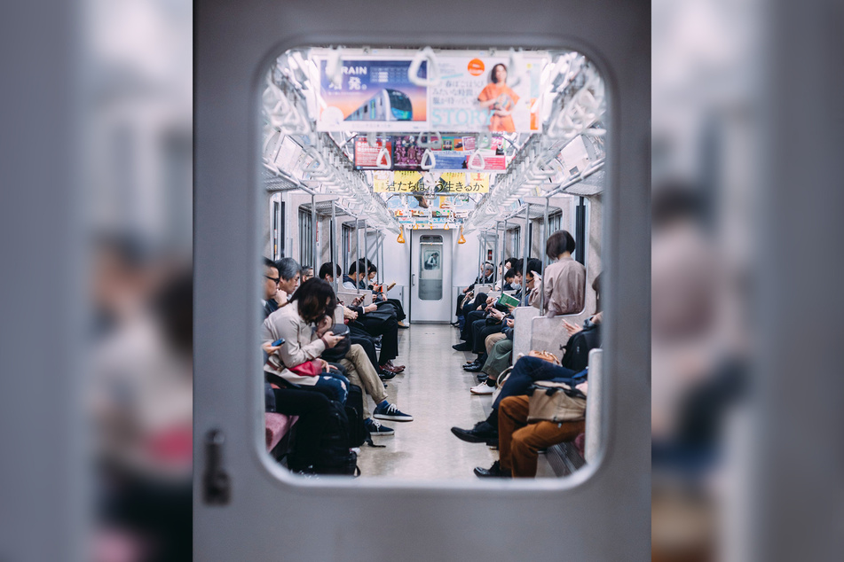 Blick in eine U-Bahn in Tokio. Viele Japaner schauen auf ihre Handys.