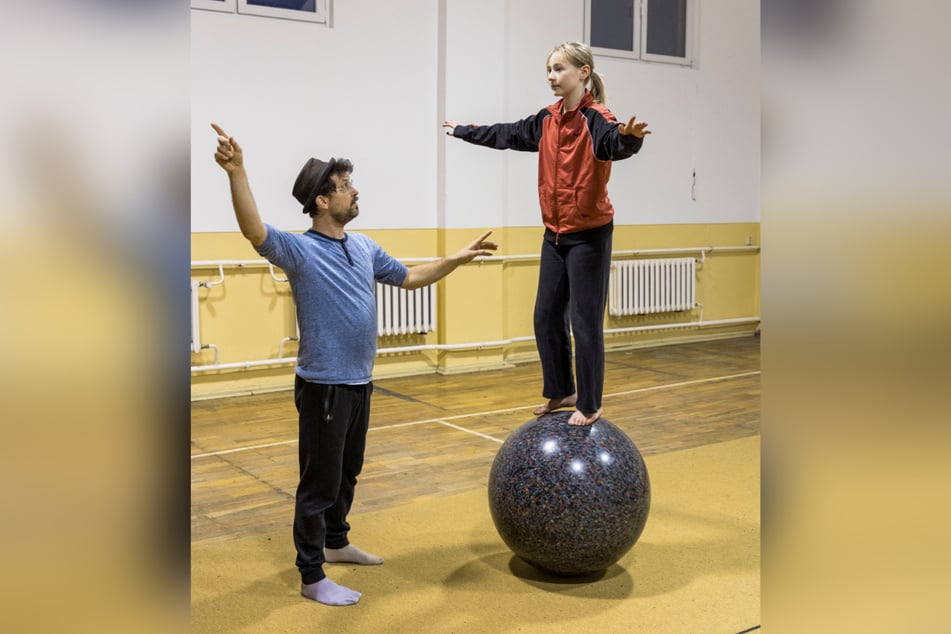 Trainer Philipp Schneider (39) übt mit Nora (12) das Balancieren auf einer großen Kugel.