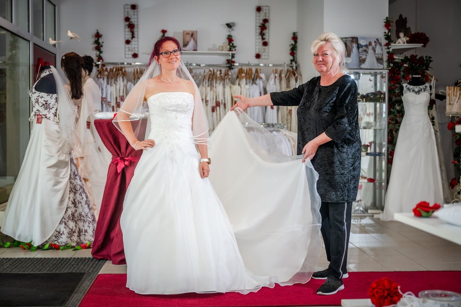 Inhaberin des Geschäfts "Chemnitzer Brautmoden", Katrin Handke (61, r.), hilft Kundin Peggy Wagner (35) bei der Anprobe.