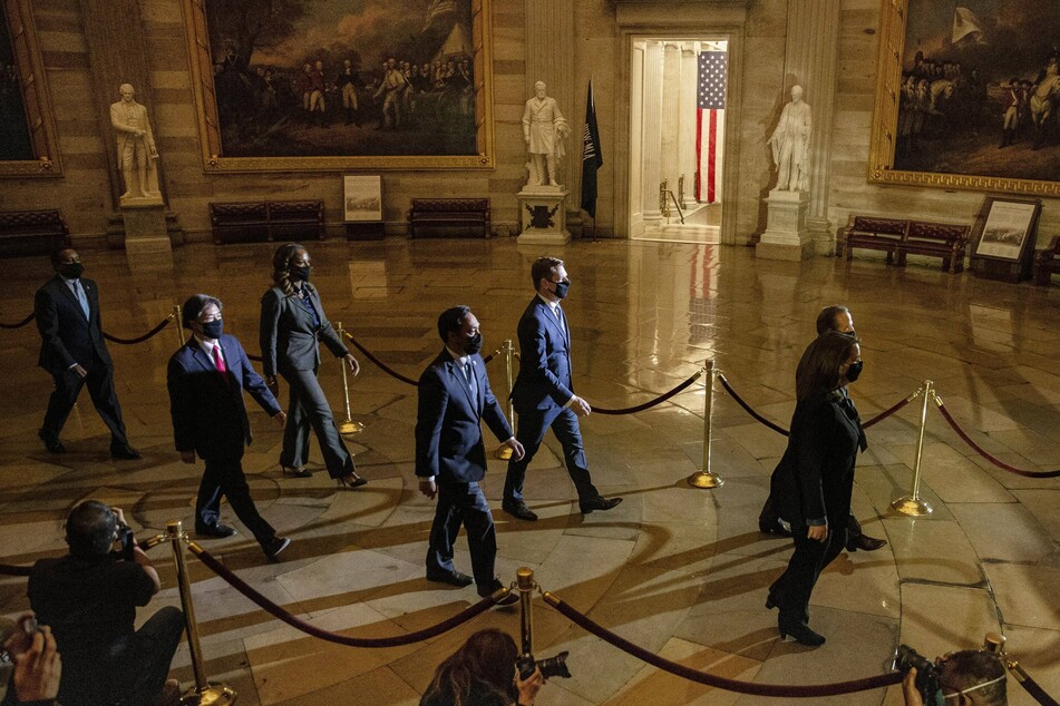 Impeachment managers walk through the Capitol rotunda to deliver the article to the Senate.