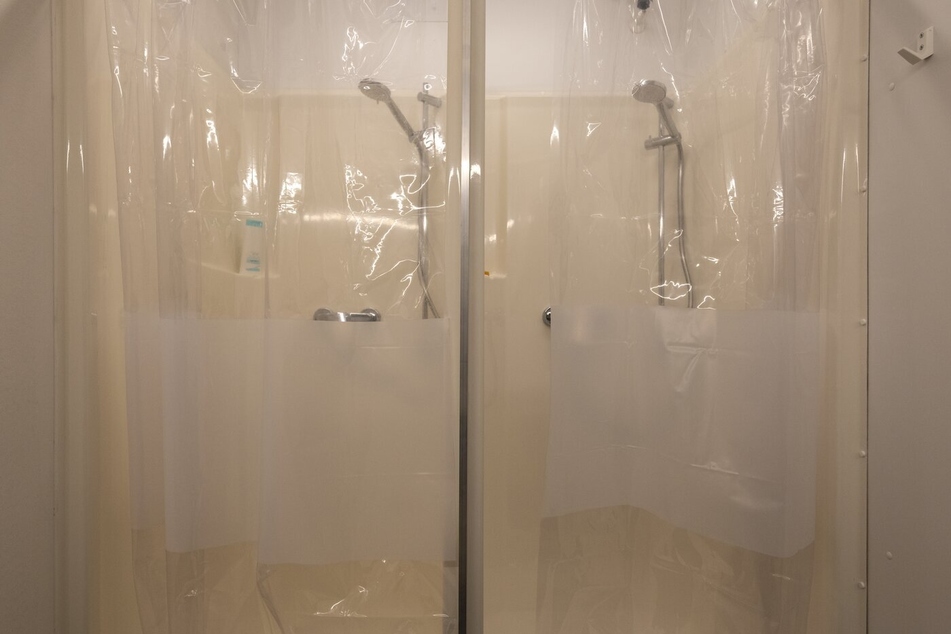 Zwei Duschen direkt nebeneinander mit durchsichtiger Folie, die sicher überall klebt.