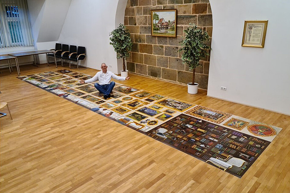 17,63 Quadratmeter Meisterwerk: Peter Schubert sitzt auf seinem (un-)vollendetem Rekord-Puzzle.