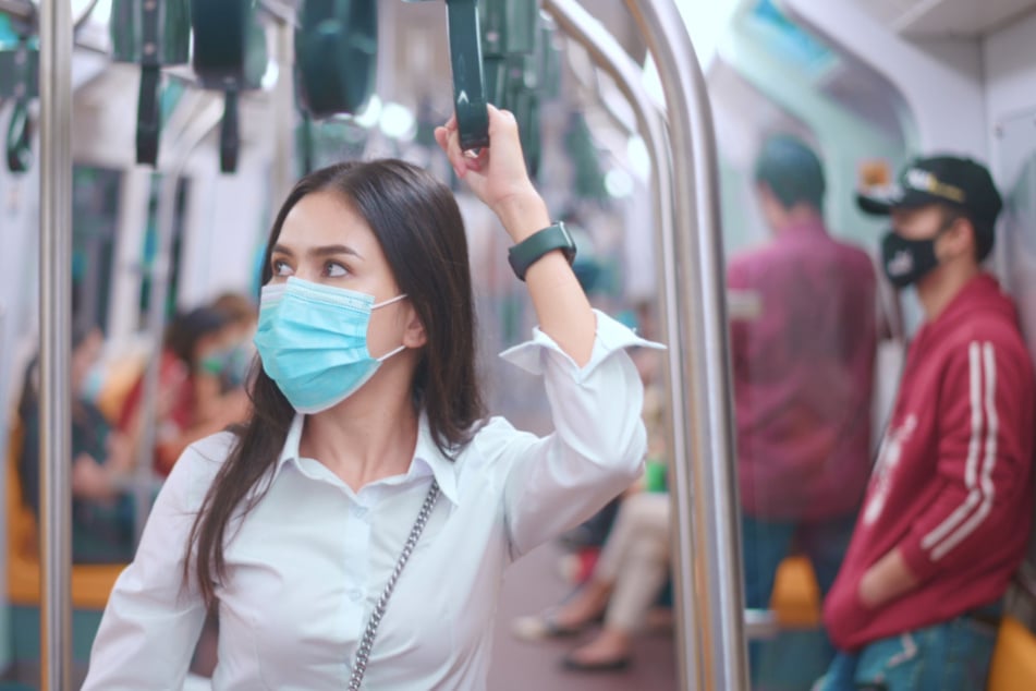 Masken tragende Menschen im öffentlichen Nahverkehr.