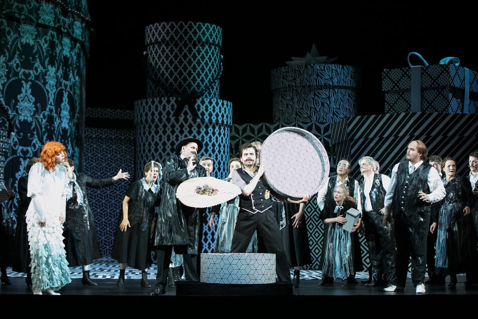 Rosalia Cid (Elena), Florian Stern (Onkel Vézinet), Piotr Buszewski (Fadinard), Alexander Grassauer (Nonancourt, v.l.) samt dem Staatsopernchor zwischen Hutschachteln.