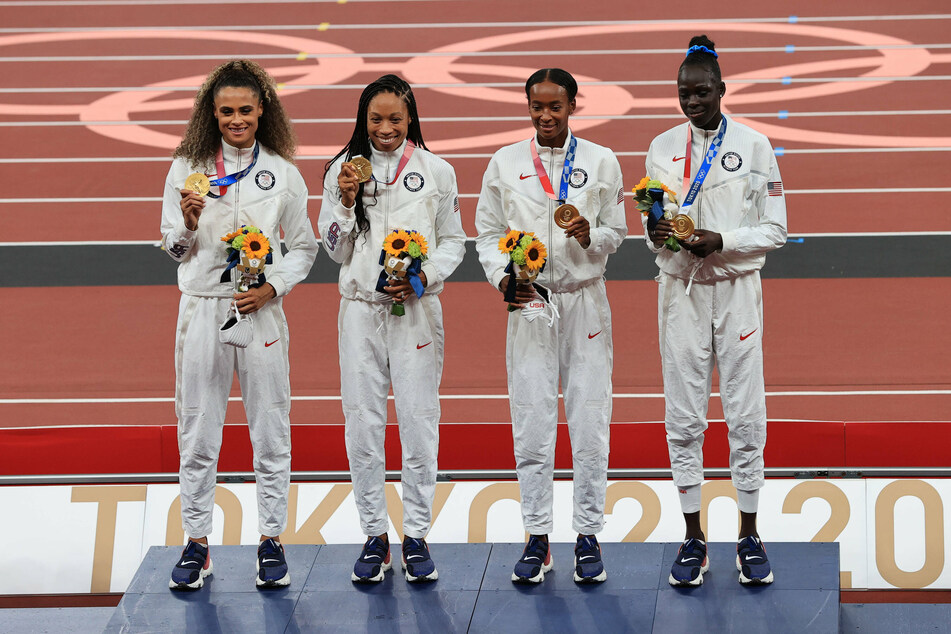 Allyson Felix (2nd from left), Athing Mu (far right), Dalilah Muhammad (2nd from right), and Sydney McLaughlin (far left) of Team USA pose with their gold medals.