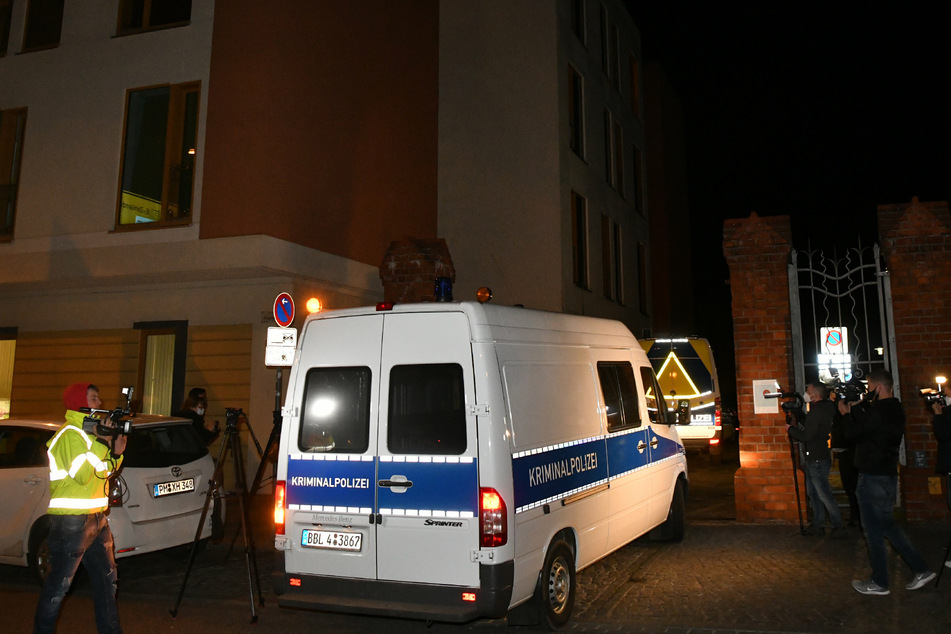 Das Einsatzfahrzeug der Kriminaltechnik der Polizei fährt an Journalisten vorbei auf ein Klinikgrundstück in Potsdam.