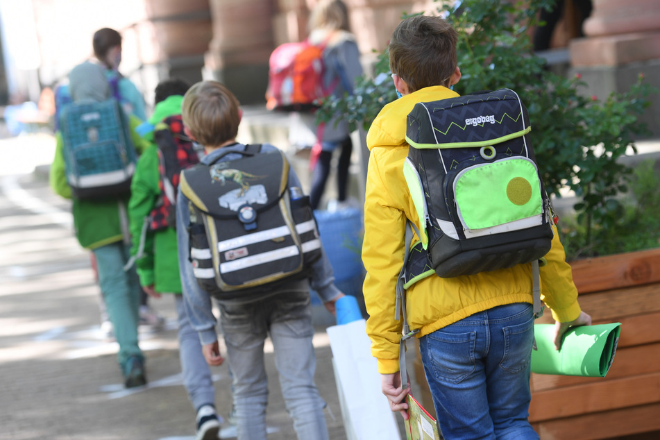 Schüler einer vierten Klasse gehen über den Schulhof.