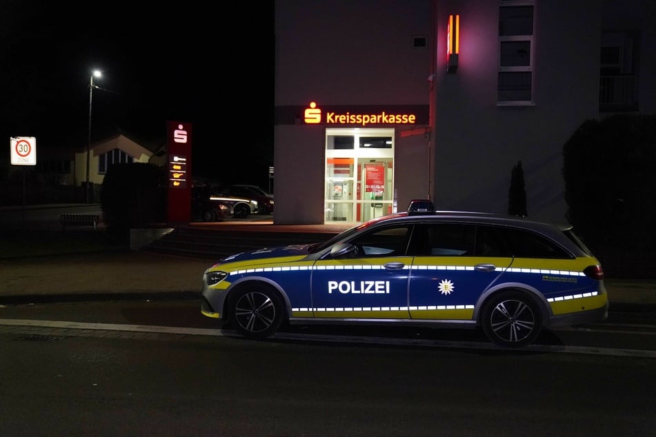 Ein Polizeiauto steht am Freitagabend vor der Filiale.