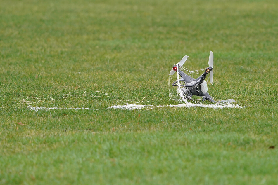 Eine Drohne, eingefangen mit einem Netz einer Abwehrdrohne, liegt nach der Projektvorstellung des zivilen Abwehrsystems gegen Drohnen ("Falke") auf dem Gelände der Universität der Bundeswehr.