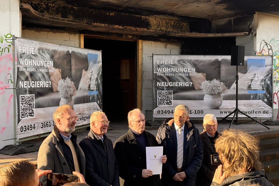 Die Spuren des Brandes sind während des Termins mit Haseloff im Hintergrund deutlich zu sehen.