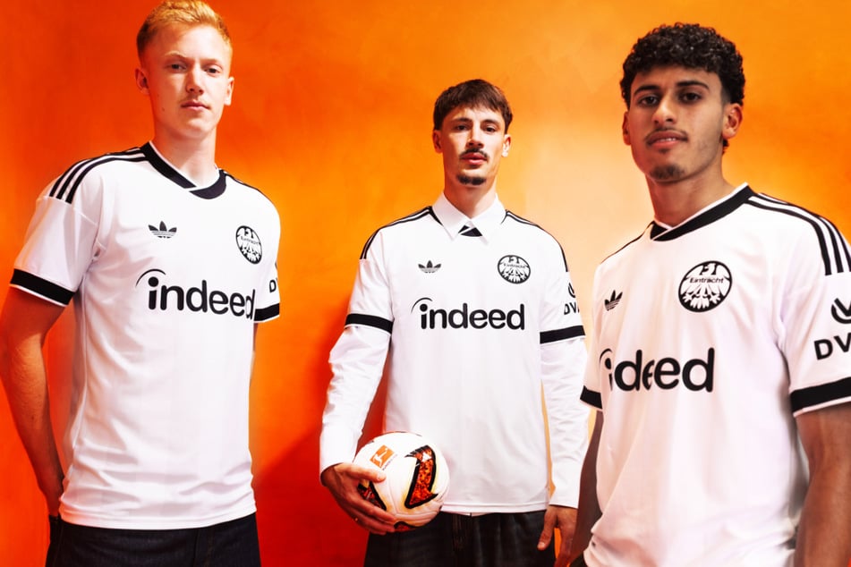 Die Spieler Hugo Larsson (22, v.l.), Robin Koch (30) und Ayoube Amaimouni-Echghouyab (21) präsentieren das neue Auswärts-Trikot von Eintracht Frankfurt.