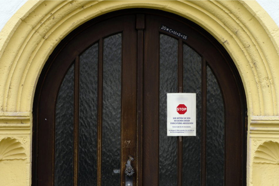 Würzburg: An einer Zugangstür zu einem Seniorenheim ist ein Schild angebracht, das von Besuchen dieser Einrichtung abrät. (Archivbild)