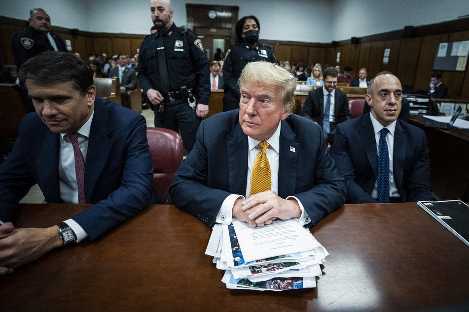 Former President Donald Trump (c.) with attorneys Todd Blanche (l.) and Emil Bove (r.) attends his criminal trial at Manhattan Criminal Court on Wednesday in New York City.