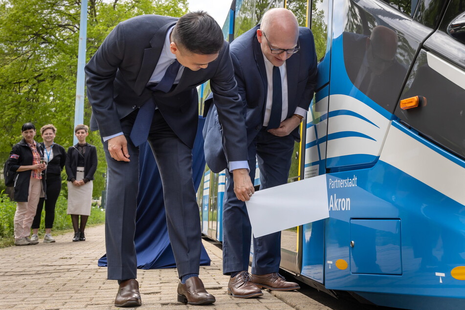 Oberbürgermeister Sven Schulze und der amerikanische Konsul Kenichiro Toko bei der Einweihung einer neuen Straßenbahn, die den Namen Akron trägt.