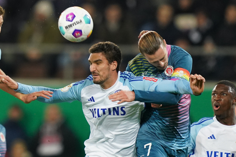 Schalkes Marcin Kaminski (l) setzt sich gegen St.-Pauli-Kapitän Jackson Irvine durch und erzielt das 1:0 für seinen Verein.