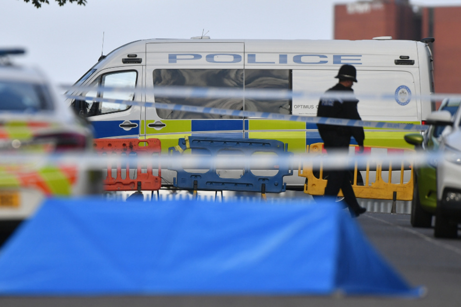 Ein Polizeibeamter und Fahrzeuge der Polizei stehen an einer Absperrung in der Irving Street in Birmingham, nachdem im Stadtzentrum mehrere Menschen durch Messerstiche verletzt worden sind.