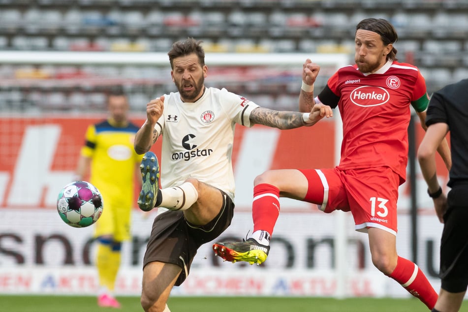 Startelf-Rückkehrer Guido Burgstaller (l.) konnte dem Spiel des FC St. Pauli nicht seinen Stempel aufdrücken, wurde von den Düsseldorfern um Adam Bodzek (r.) abgemeldet.