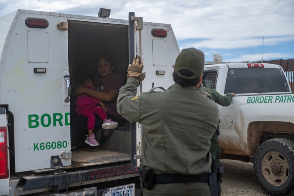 Mexican migrant Mariana (38) holds her daughter Liani in the back of a border patrol vehicle after being apprehended by US Customs and Border protection officers after crossing over into the US on June 26, 2024 in Ruby, Arizona.