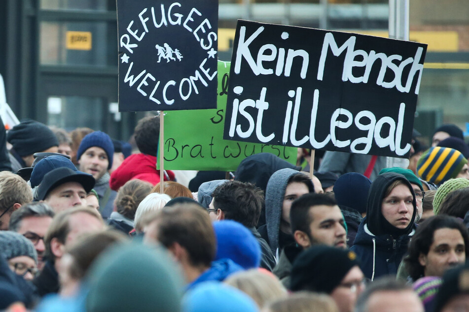 Demonstranten mit den Plakaten "Kein Mensch ist illegal" und "Refugees welcome" in Dresden.