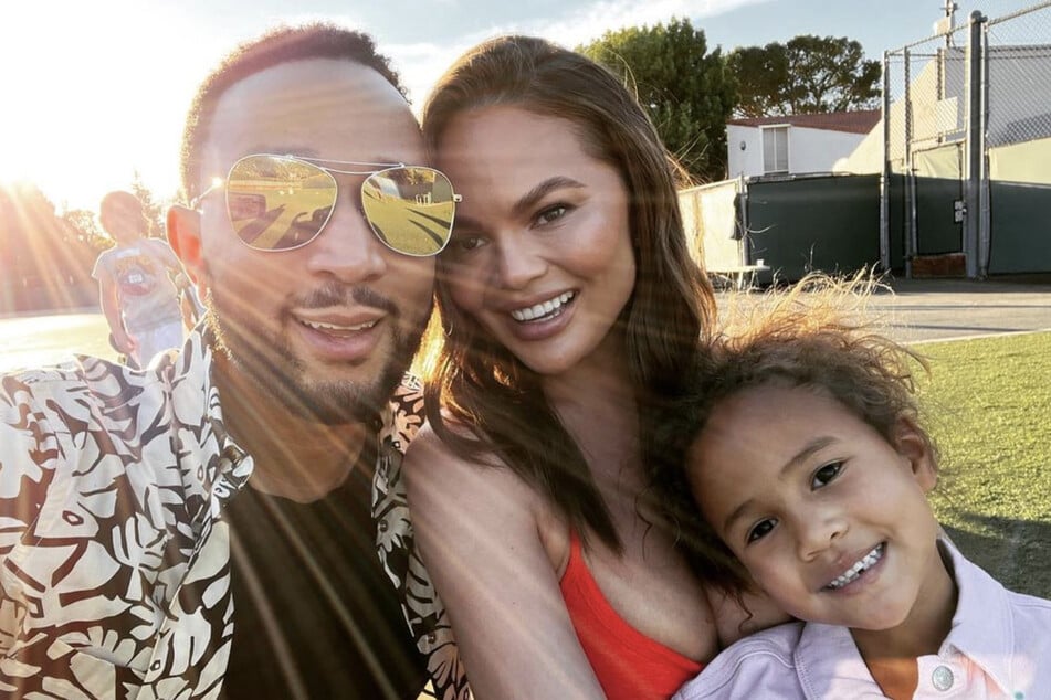 John Legend (front l.) and Chrissy Teigen are all smiles with their children, Luna (r.) and Miles (back l.).