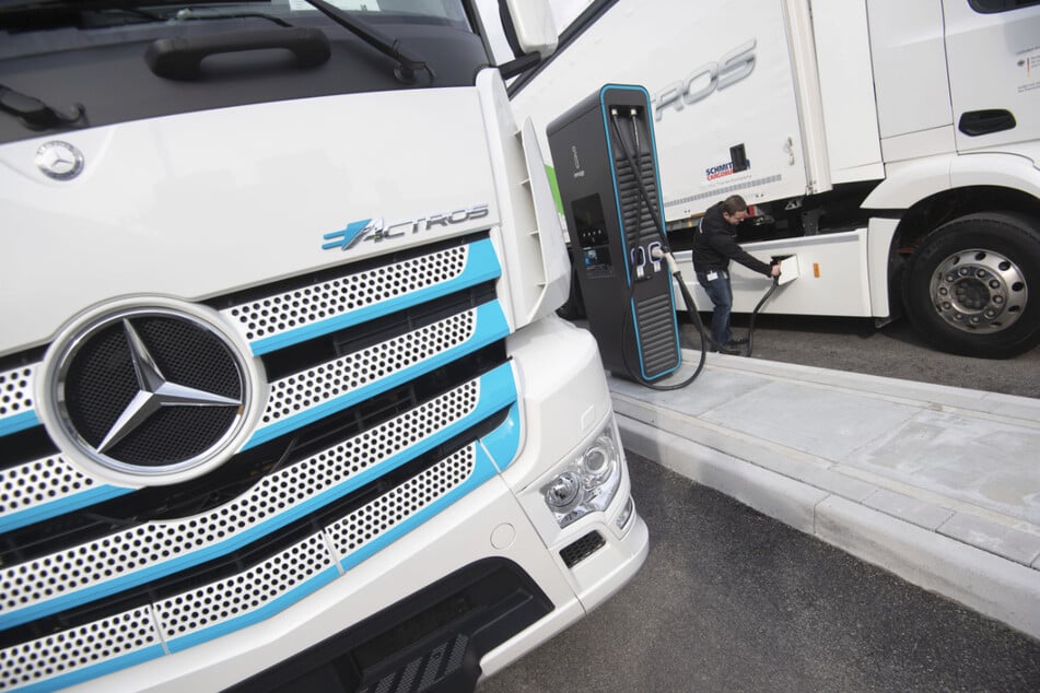 Ein Mitarbeiter steckt einen Ladestecker in einen elektrisch angetriebenen Mercedes-Benz eActros. Daimler bringt Lkw-Sparte an die Börse.