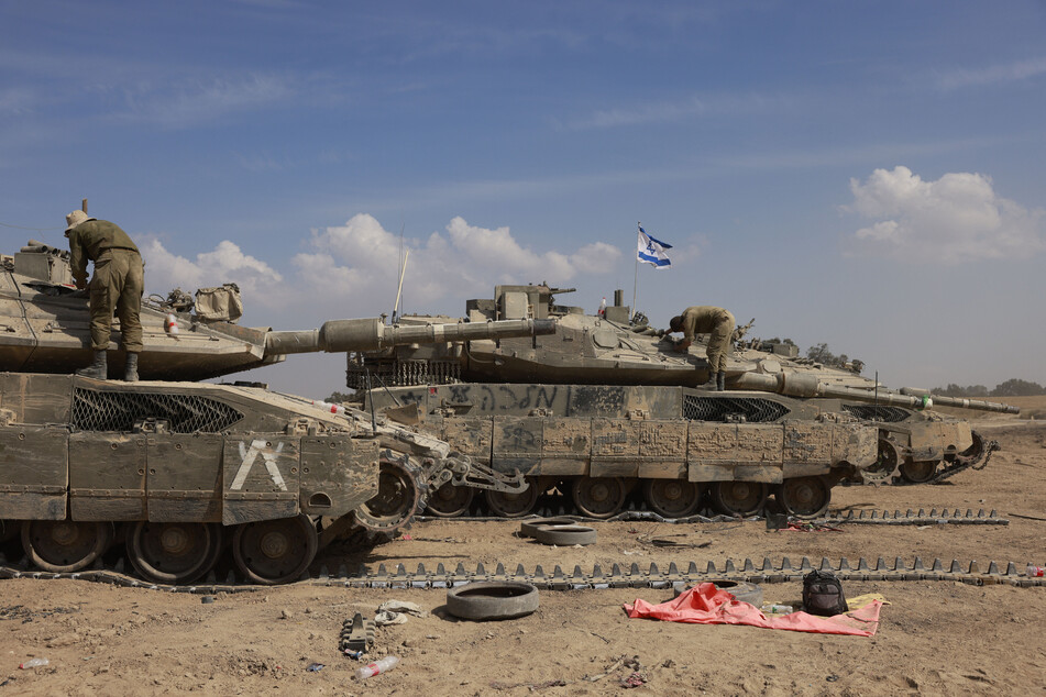 Israeli soldiers work on their tanks in an army camp near Israel's border with the Gaza Strip on Monday, amid the ongoing conflict between Israel and the militant group Hamas.