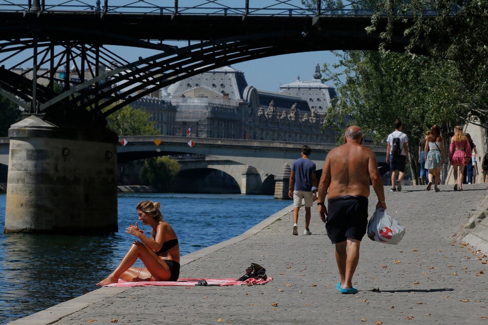 Eine Frau genießt das sonnige Wetter am Seineufer in Paris.