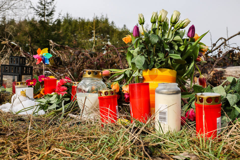 Kerzen und Blumen liegen in einem Wald im südlichen Nordrhein-Westfalen an der Stelle, wo die zwölfjährige Luise am Wochenende tot aufgefunden worden war.