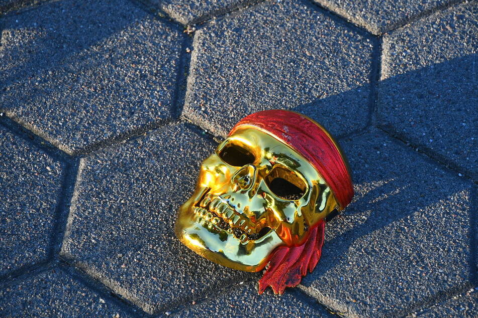 Diese Maske soll der Mann beim unerlaubten Überqueren der Straße getragen haben. Der goldene Totenkopf blieb an der Unfallstelle zurück.