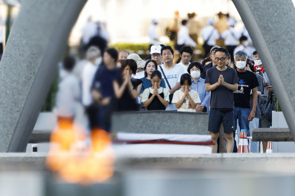 People pray in front of the cenotaph for the victims of the 1945 atomic bombing, on the anniversary of the world's first atomic bombing, at Peace Memorial Park in Hiroshima, Japan.
