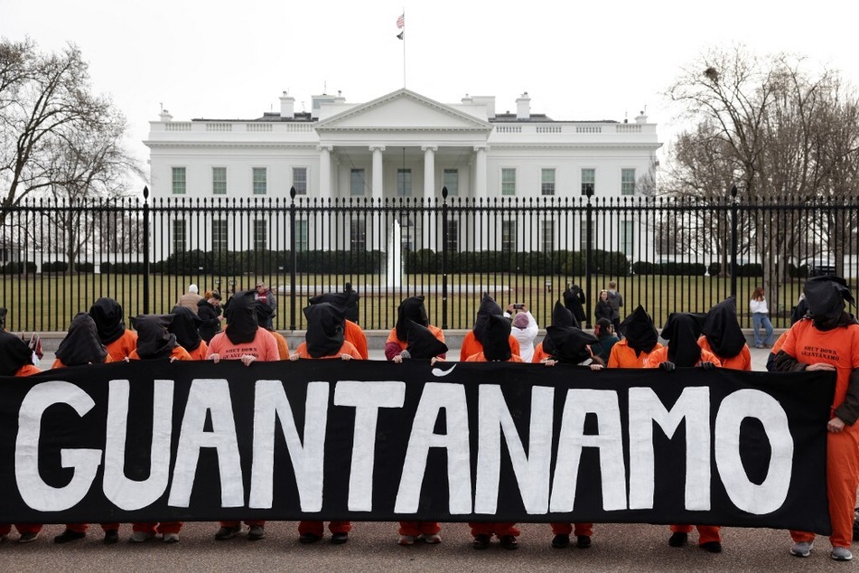 Activists in orange jumpsuits, representing the men who are still being held at the US detention facility in Guantanamo Bay, Cuba, protest in front of the White House on January 11, 2023.
