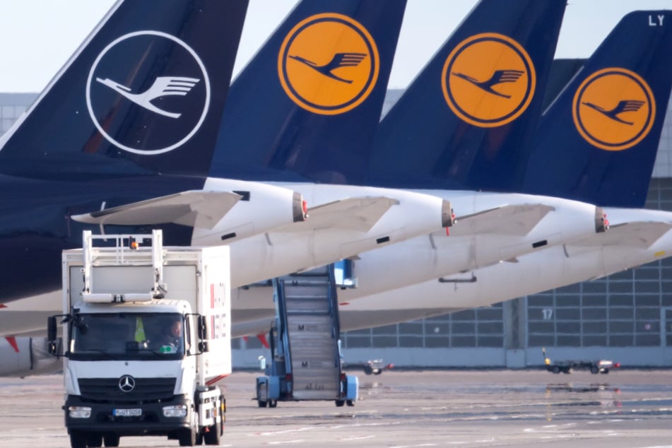 Flugzeuge der Lufthansa stehen auf dem Vorfeld eines Flughafens.