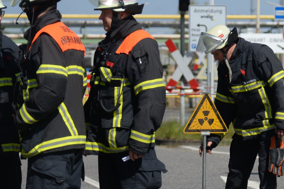 Ein Feuerwehrmann stellt ein Warnschild vor dem Betrieb auf.