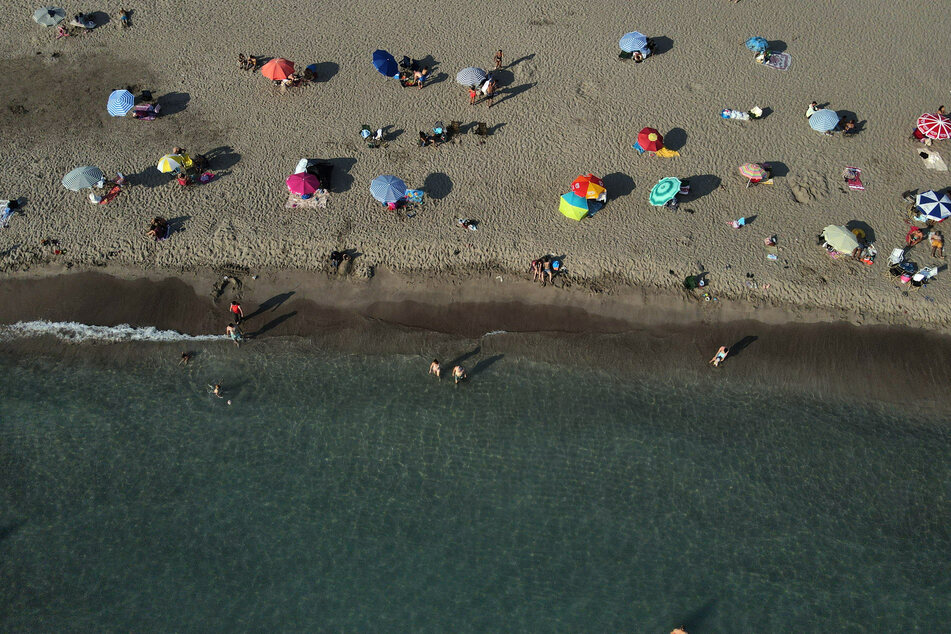 Badegäste genießen das Mittelmeer am sonnigen Patara-Strand an der Süd-Ost-Küste der Türkei.