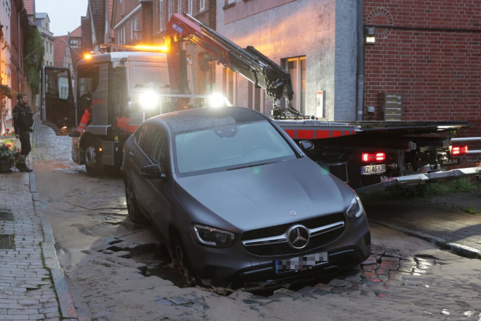 In der Kleinstadt Lauenburg/Elbe ist ein Mercedes nach einem Wasserrohrbruch teilweise in eine unterspülte Straße eingebrochen.