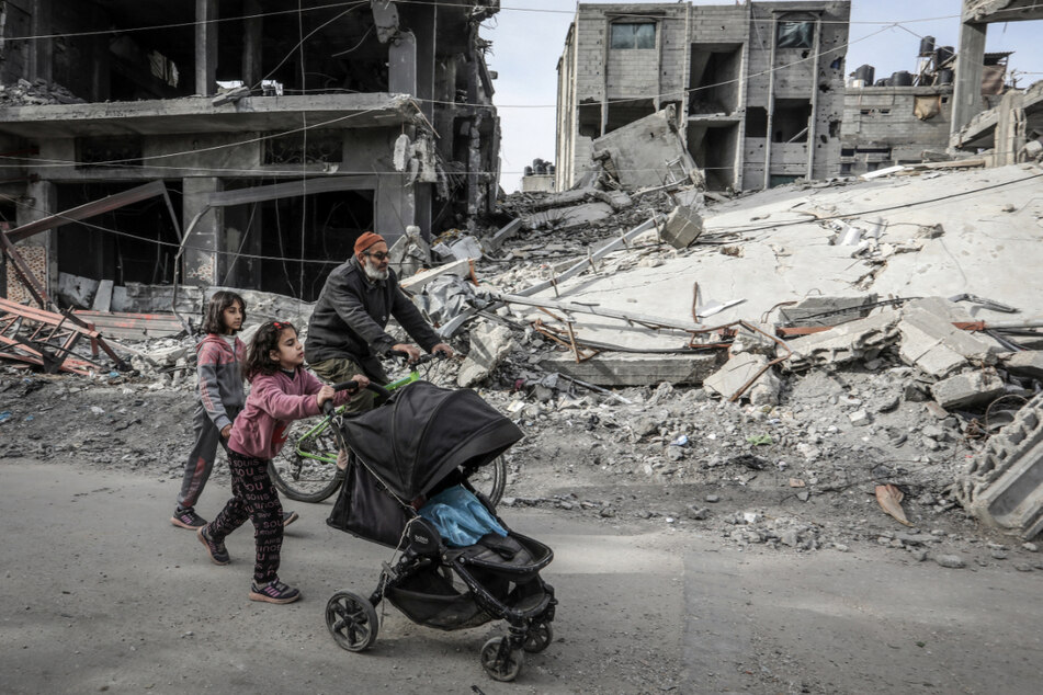 Palästinenser gehen in Rafah an Gebäuden vorbei, die von israelischen Luftangriffen zerstört wurden.