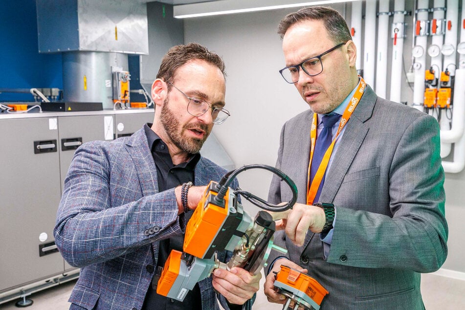 Training Manager René Kindel (37, l.) erklärte am Donnerstag Sachsens Wirtschaftsminister Dirk Panter (50, SPD) die Funktionsweise eines Steuerelements von Belimo.