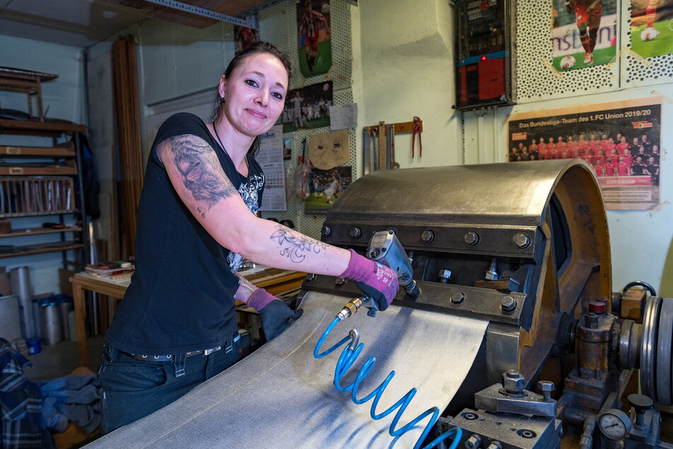 Luise Roy (36) arbeitet mit Zinnplatten für die Pfeifen an einer Hobelmaschine.