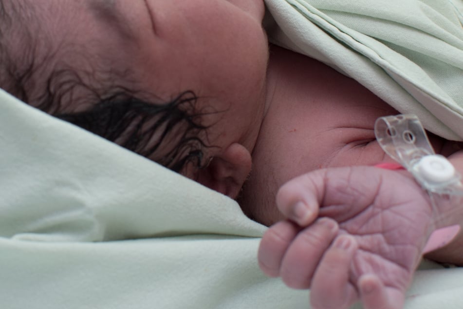 Hebamme trennt Finger von Baby beim Nabelschnur-Durchschneiden ab