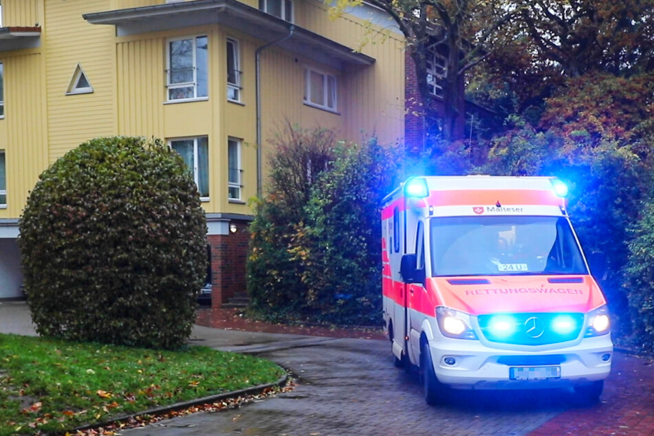 Ein Rettungswagen steht mit Blaulicht vor dem Ort des Unglücks.
