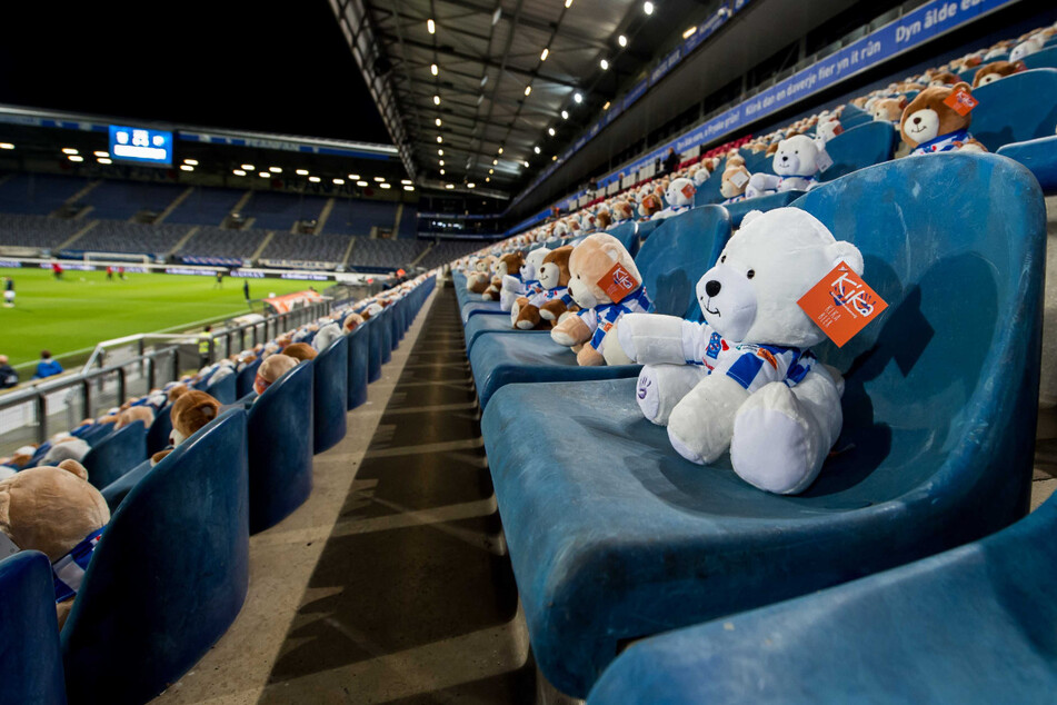 Keine Fans wegen der verschärften Coronamaßnahmen, aber auf der Tribüne sitzen 15.000 Teddybären mit einem Fußballtrikot.