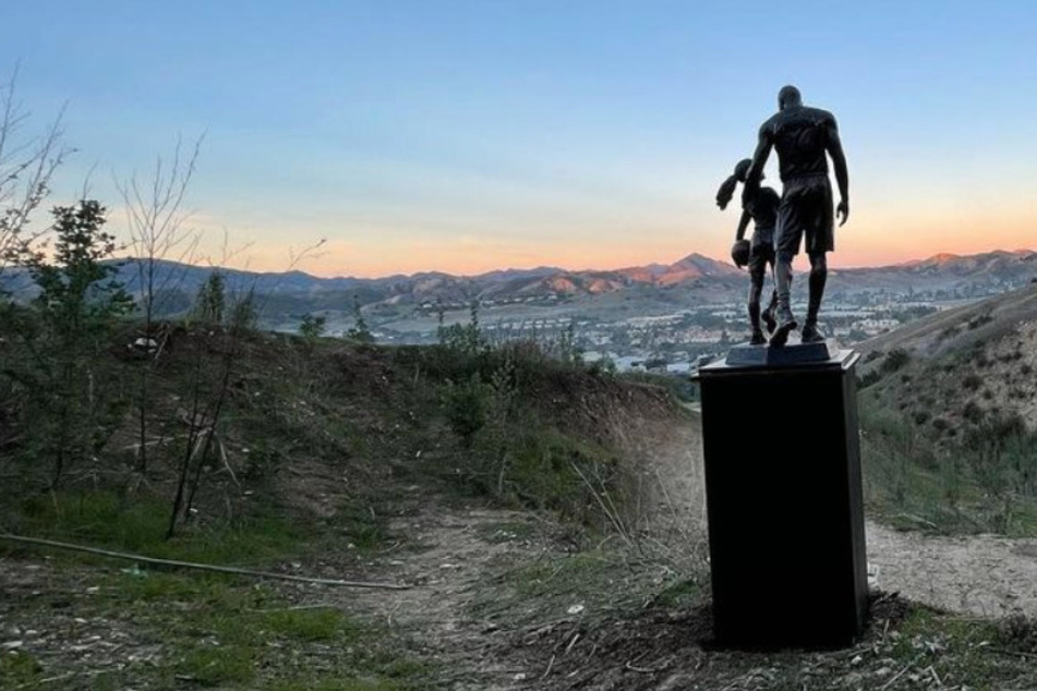 A sculpture of Kobe Bryant and his daughter Gigi has been placed at the site of the helicopter crash that killed them.