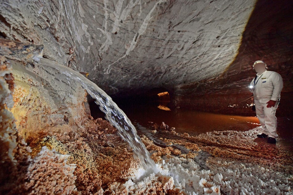Ein Bergmann betrachtet den Wasseraustritt in einer Kali-Grube. (Symbolbild)