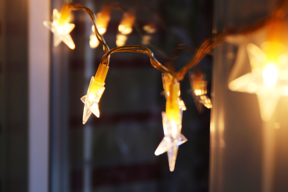 Eine LED-Lichterkette hängt an einem Fenster: Die Adventszeit naht (Symbolbild).